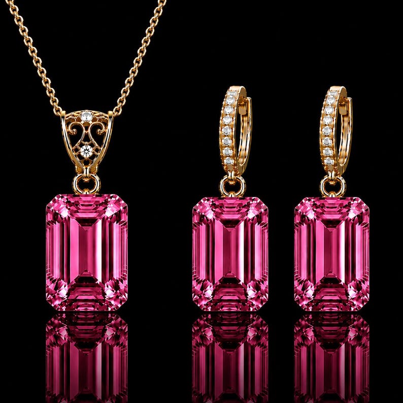 May include: A jewelry set featuring a gold necklace and two matching hoop earrings. Each piece displays a large, rectangular, emerald-cut pink gemstone. The necklace pendant and earring hoops are accented with small, clear, round-cut white stones.