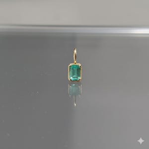Pingente artesanal em ouro 14k com esmeralda e gema retangular verde.