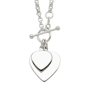 Puede incluir: Un collar plateado con cierre de palanca y un colgante de doble corazón. El colgante presenta dos formas de corazón superpuestas, una ligeramente más pequeña que la otra. La cadena es de estilo eslabones.