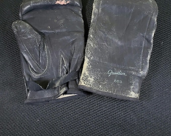 May include: A pair of black leather boxing gloves with a white label that reads "Grondier 663".