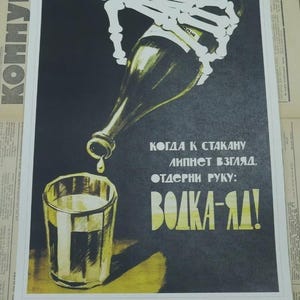 Puede incluir: Cartel de propaganda vintage con fondo negro y detalles amarillos y blancos. Una mano esquelética vierte líquido de una botella a un vaso. El texto en ruso dice "¡El vodka es veneno!"