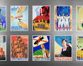 May include: A collection of ten vintage-style propaganda posters with Korean text. The posters feature illustrations of people, nature, and symbols, with bold colors and text. The posters are displayed on a metallic surface.