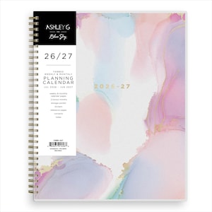 May include: A spiral-bound planner with a watercolor design in pastel pink, blue, and gold. The cover features the text "26/27" and "2026-27". Includes weekly and monthly calendar pages, stickers, and a storage pocket.
