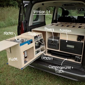Puede incluir: Un kit de conversión interior para furgoneta camper de madera clara etiquetado como Version L1, que incluye una cocina extraíble con fogón, almacenamiento para ollas, vajilla, estación de energía, nevera y espacio para sillas y mesa.