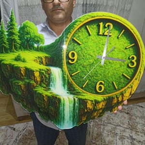 May include: A unique wall clock featuring a vibrant green landscape with a waterfall and trees. The clock face is a bright green with gold-colored numerals and hands. The clock measures approximately 18 inches in diameter.