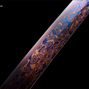 May include: Close-up of a blade with a unique pattern. The blade features a swirling design in shades of blue, orange, and purple against a dark background. The text "Flexi-casa" is in the upper left corner.