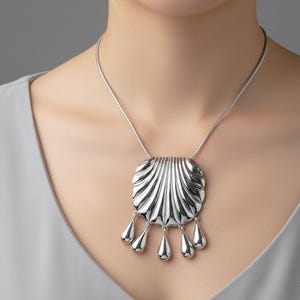 Collar con colgante de concha grande de plata con cadena y borla en forma de gota de agua.