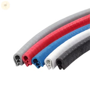 Op de afbeelding: Close-up van vijf U-vormige randafwerkingsstukken in verschillende kleuren: grijs, rood, blauw, wit en zwart. De afwerking heeft een getextureerd oppervlak en is ontworpen om randen te beschermen.