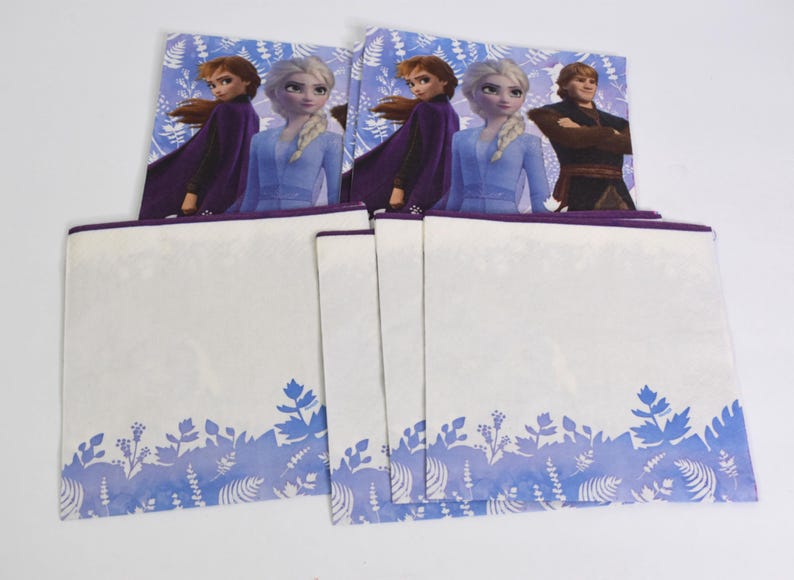 Pode incluir: Um conjunto de guardanapos para festas com o tema Frozen. Os guardanapos apresentam imagens de Elsa, Anna e Kristoff. A parte inferior dos guardanapos tem um desenho floral azul e branco. Os guardanapos s&atilde;o brancos com uma borda roxa.