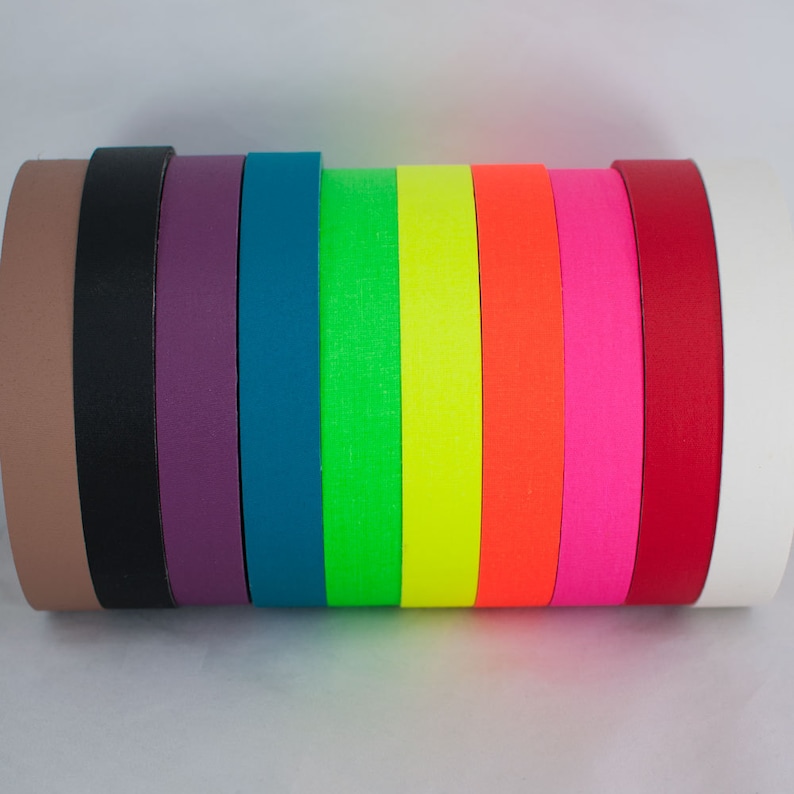 Pu&ograve; includere: Assortimento di rotoli di nastro adesivo colorati in vari colori, tra cui marrone, nero, viola, verde acqua, verde, giallo, arancione, rosa, rosso e bianco.