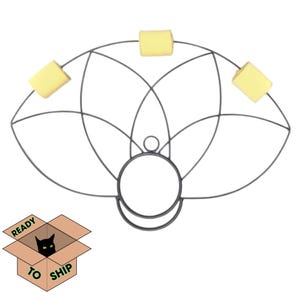 May include: A black metal fire fan with three yellow fire wicks. The fan has a circular handle and a geometric design. The words "READY TO SHIP" are printed on a cardboard box with a black cat.