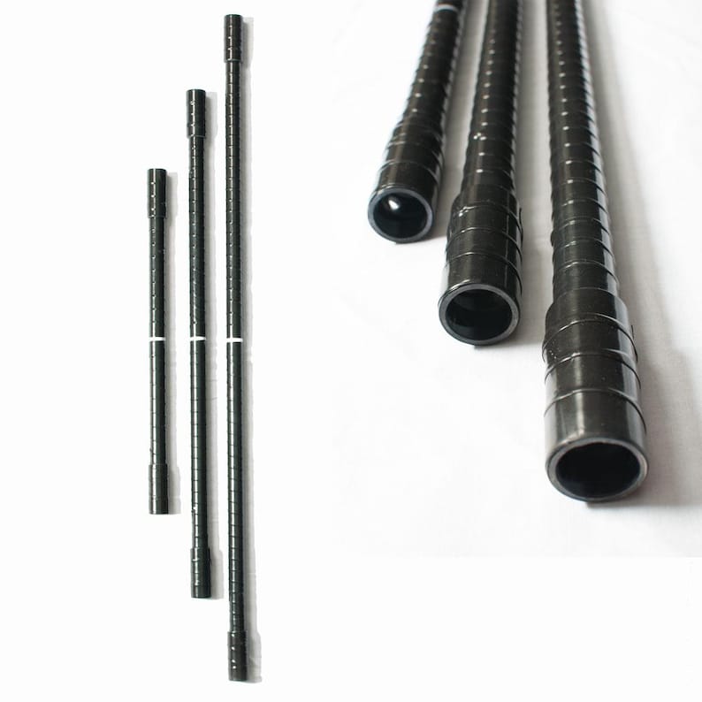 May include: Black metal shelf poles of varying lengths are arranged against a white background. The poles have a ridged texture and are hollow at the ends. The image shows a set of shelf poles, likely for a shelving unit.