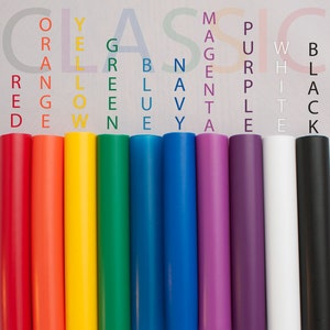 Puede incluir: Un conjunto de diez rollos de vinilo de colores, cada uno etiquetado con un nombre de color: rojo, naranja, amarillo, verde, azul, azul marino, magenta, morado, blanco y negro. Los rollos están dispuestos en orden de arcoíris.