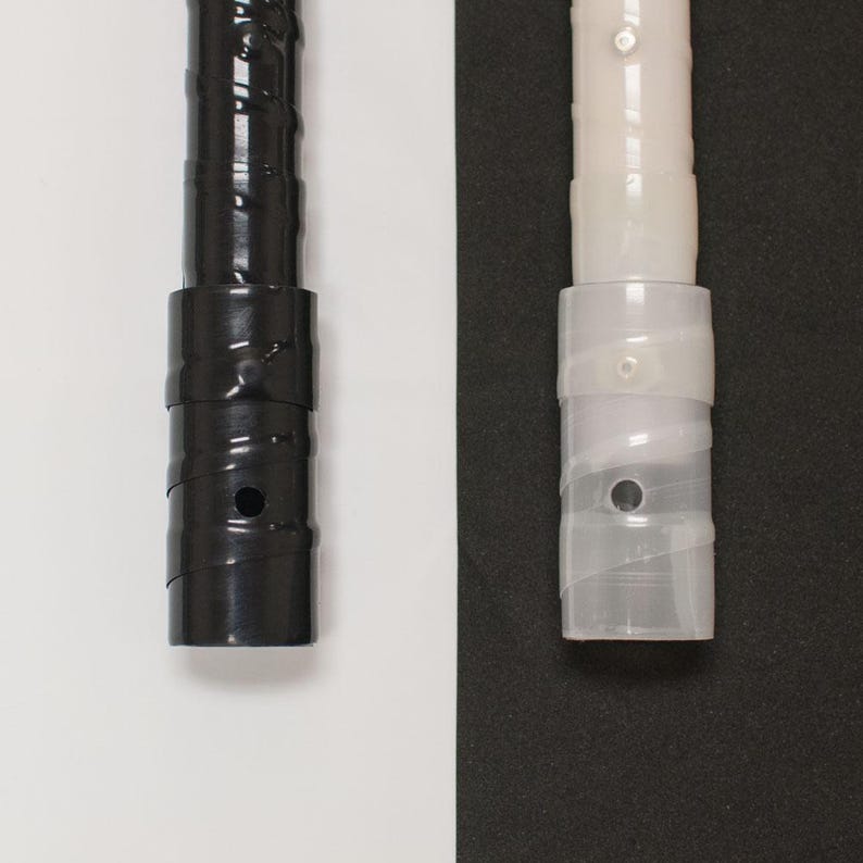 May include: Close-up of two shelf support poles. One is black, the other is clear. Both have a cylindrical design with a series of ridges and a circular hole. The black pole is on a white background, and the clear pole is on a black background.