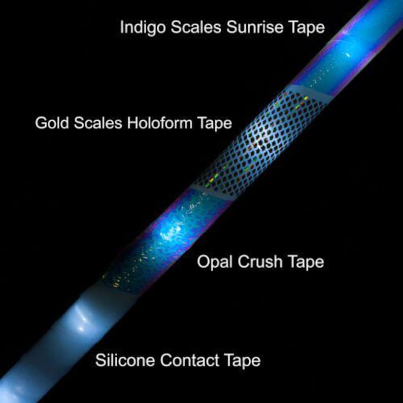 May include: A diagonal view of a glowing, iridescent tape with the text "Indigo Scales Sunrise Tape", "Gold Scales Holoform Tape", "Opal Crush Tape", and "Silicone Contact Tape" on a black background. The tape has blue, gold, and opal colors.
