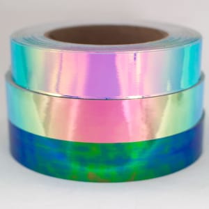 May include: Three rolls of iridescent tape in blue, green, and pink colors. The tape is wrapped around cardboard cores.
