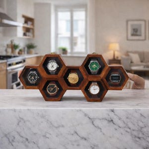 May include: A wooden watch display case in a honeycomb design, holding seven watches with various face designs and band colors. The case is made of dark wood and sits on a marble countertop. The watches include silver, gold, and black watch faces.