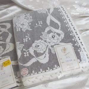 May include: White lace tablecloths with floral patterns are displayed. The tablecloths are packaged and labeled with the size 16 x 68 inches. The labels also indicate the material composition of 95% cotton and 5% polyester.
