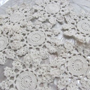 Puede incluir: Tapetes de ganchillo hechos a mano, de color blanco roto. Los tapetes presentan un diseño floral con un patrón de espiral central y detalles calados. Estas piezas decorativas son ideales para añadir un toque vintage a la decoración del hogar.