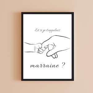 Op de afbeelding: Zwart ingelijste print met een lijntekening van een babyhand die de vinger van een volwassene vasthoudt. De Franse tekst "Et si je t'appelais marraine ?" staat op een witte achtergrond in een stijlvol lettertype.