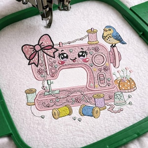 May include: Pink embroidered sewing machine with a cute face, bow, and floral details. A blue bird sits on the machine. Spools of thread in yellow, blue, and purple are scattered around the machine. A pin cushion and thimble are also present.