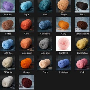 May include: A collection of yarn skeins in various colors, including purple, blue, orange, and pink. Each skein is labeled with its color name, such as "Amethyst," "Aqua," and "Orange." The yarn is arranged on a dark background.