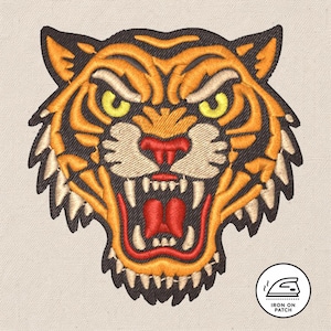 May include: Embroidered tiger head patch with orange, yellow, and black details. The tiger has an open mouth with visible teeth and a red tongue. The patch is on a light beige background, with a small circular "Iron On Patch" logo.