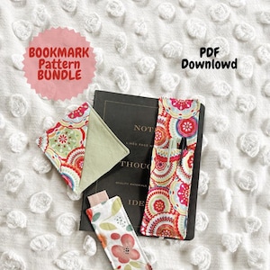 Può includere: Una collezione di segnalibri in tessuto fatti a mano e un portapenne, con motivi floreali e geometrici colorati. L'immagine include un taccuino e il testo "Bookmark Pattern Bundle" e "PDF Download".