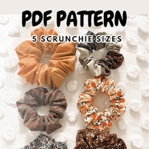 Może przedstawiać: Sześć gumek do włosów z tkaniny w różnych wzorach i kolorach, w tym pomarańczowe z białymi kropkami, szare z czerwonymi kropkami i kwiatowe wzory. Tekst "PDF PATTERN" i "5 SCRUNCHIE SIZES" jest wyświetlany u góry.
