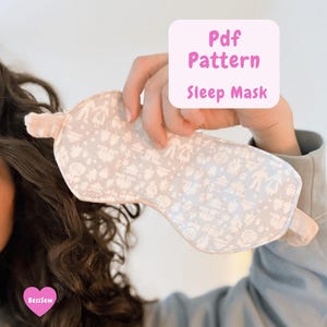 May include: A light gray sleep mask with a white pattern, held up by a hand. The mask has a light pink trim and elastic band. Text on the image reads "Pdf Pattern Sleep Mask".