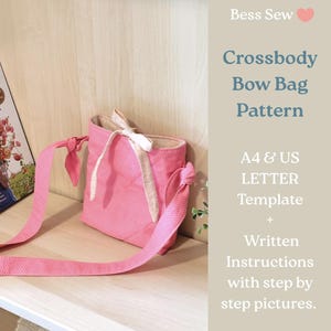 May include: A pink crossbody bag with a bow detail and a white polka dot pattern. The bag has a long strap and is displayed on a wooden shelf. Text on the right side reads "Crossbody Bow Bag Pattern".