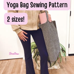 Puede incluir: Una bolsa de yoga de tela gris jaspeada que contiene una esterilla de yoga rosa. El texto Yoga Bag Sewing Pattern y 2 sizes! aparece en recuadros rosas. La marca BessSew está impresa en rosa. La bolsa tiene una sola correa para el hombro.
