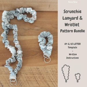 May include: A scrunchie lanyard and wristlet pattern bundle. The scrunchie and lanyard are made of a light blue and gray patterned fabric. The lanyard has a silver-colored clasp. The text on the image reads "Scrunchie Lanyard & Wristlet Pattern Bundle".