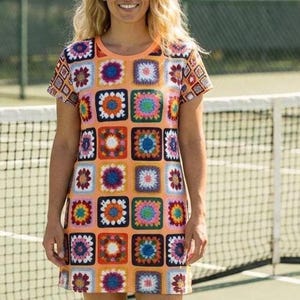 Könnte beinhalten: Ein orangefarbenes Kleid mit kurzen Ärmeln und einem bunten Häkelmuster aus Quadraten. Das Kleid hat einen runden Ausschnitt und eine gerade, lockere Passform. Die Häkelquadrate sind in verschiedenen Farben wie Blau, Rosa, Grün und Orange gehalten.