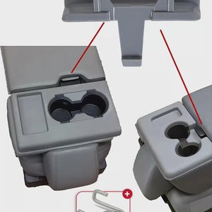 May include: A gray car console with cup holders and a storage compartment. The image shows the console in different views, along with a silver metal spring. The console is designed to fit between the front seats of a vehicle.
