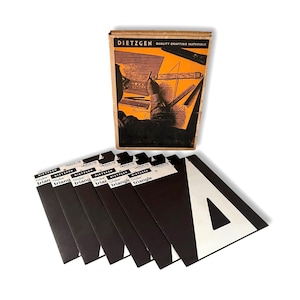 Puede incluir: Un juego de materiales de dibujo Dietzgen vintage. El juego incluye una caja de cartón con el logotipo de Dietzgen y una ilustración gráfica. Varias plantillas triangulares Globe en blanco y negro están dispuestas debajo de la caja, cada una con un recorte triangular blanco.