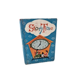 Puede incluir: Un libro infantil vintage titulado "Story Time" con una portada azul que presenta un reloj en un marco con forma de casa. La esfera del reloj es blanca con números y manecillas negras. Hay dos niños sentados frente al reloj, uno leyendo un libro y el otro sosteniendo un juguete.