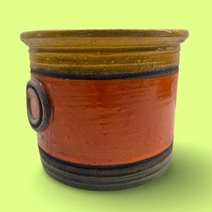 May include: A set of three ceramic mugs with a speckled, matte finish. The mugs are in shades of cream, light brown, and dark brown. Each mug has a simple, minimalist design and a rounded handle. Perfect for coffee or tea.