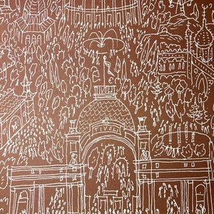 May include: A white line drawing on a brown background depicting a bustling scene of a city park. The drawing includes a large building with the word "Tivoli" above the entrance, a fountain, trees, and many small figures of people.