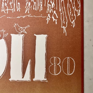 May include: A vintage poster with a brown background and white text. The text reads "OLI 80" and is surrounded by a simple illustration of a city scene with birds and trees. The poster is signed "Tryk bording grafik a/s, K&oslash;benhavn."