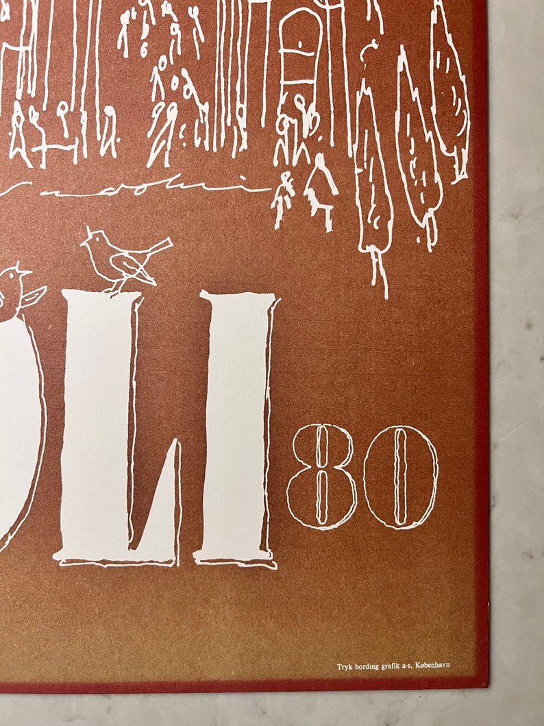 May include: A vintage poster with a brown background and white text. The text reads "OLI 80" and is surrounded by a simple illustration of a city scene with birds and trees. The poster is signed "Tryk bording grafik a/s, K&oslash;benhavn."
