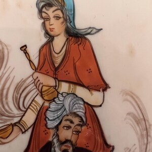 May include: A hand-painted illustration on a light surface featuring a figure wearing a blue head covering and a red tunic, holding a golden vessel. Below, a figure with a grey beard wears a white turban and a dark garment, with swirling lines.