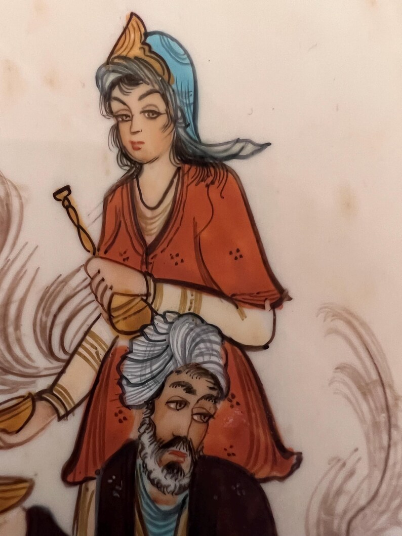 May include: A hand-painted illustration on a light surface featuring a figure wearing a blue head covering and a red tunic, holding a golden vessel. Below, a figure with a grey beard wears a white turban and a dark garment, with swirling lines.