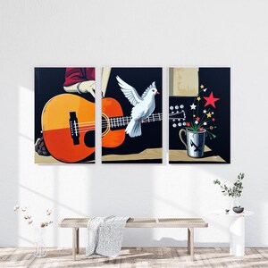 Peut inclure: Triptyque d'art mural représentant une guitare, une colombe blanche et une tasse avec des éclats d'étoiles. La guitare est orange et jaune, la colombe a les ailes déployées et la tasse a un motif d'étoile. Le fond est noir.
