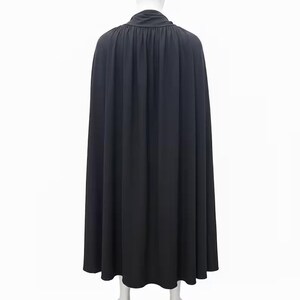 May include: A long, black cape with a high, gathered collar. The cape is made of a flowing fabric that drapes down to the ankles. The back view shows the full length and design of the garment, suitable for costumes or theatrical wear.