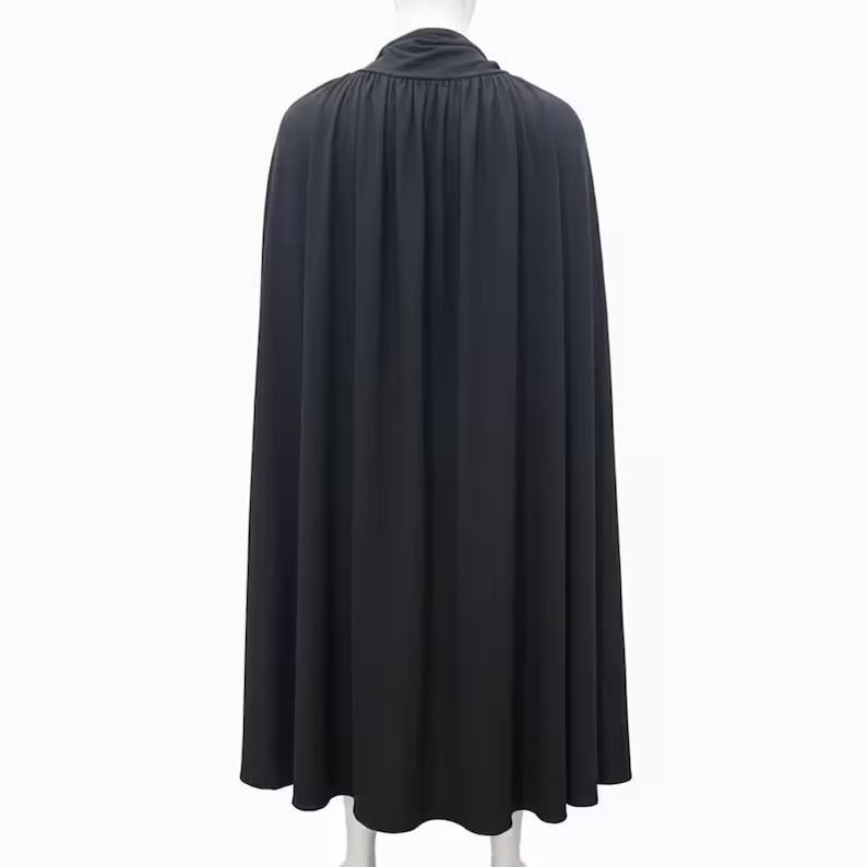 May include: A long, black cape with a high, gathered collar. The cape is made of a flowing fabric that drapes down to the ankles. The back view shows the full length and design of the garment, suitable for costumes or theatrical wear.
