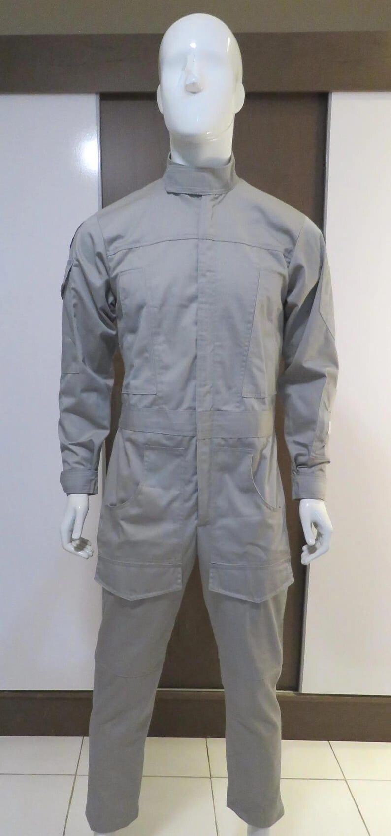 Pu&ograve; includere: Tuta grigio chiaro esposta su un manichino. L'indumento intero presenta un collo alto, maniche lunghe, tasche multiple e una vestibilit&agrave; su misura. Il manichino &egrave; bianco e si trova su uno sfondo neutro.