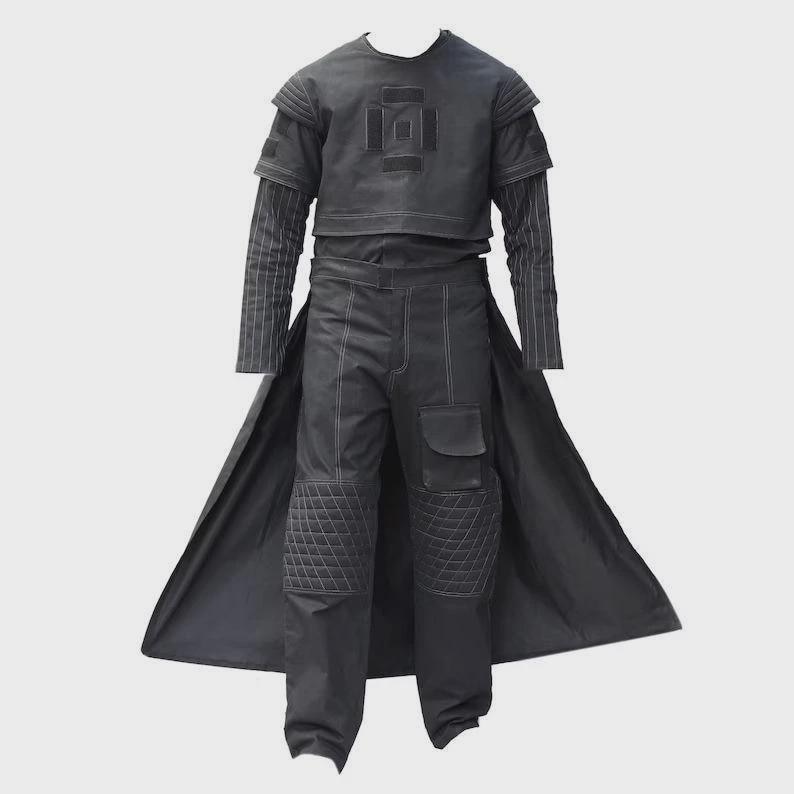 May include: A black futuristic outfit. The ensemble includes a cropped top with a geometric design, long-sleeved shirt, trousers with quilted knee pads, and a long, flowing coat. White stitching accents the seams.