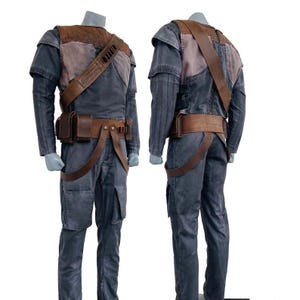 Könnte beinhalten: Ein zweiteiliges Kostüm mit grauem Overall und braunen Lederakzenten. Das Kostüm umfasst einen Schultergurt, einen Gürtel und Taschen. Das Oberteil hat ein braunes und rosa Panel auf Brust und Schultern. Die Hose hat Cargotaschen.