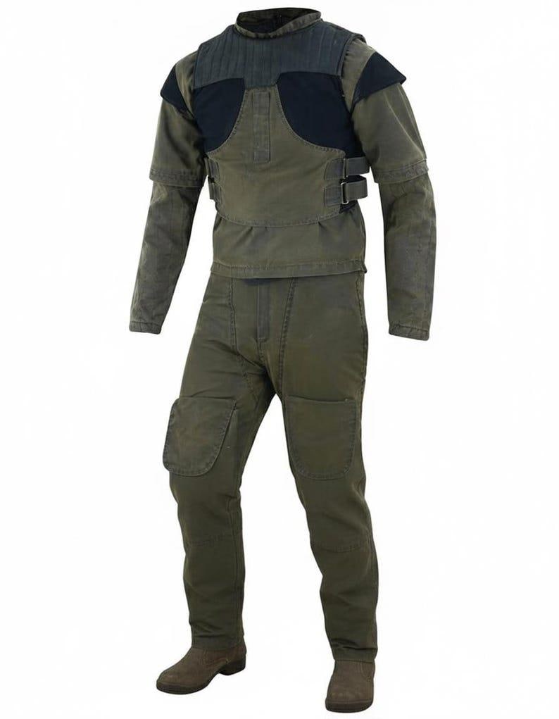 May include: A two-piece olive green work suit. The jacket has a black padded chest and shoulder area, with two buckles. The pants have knee patches. The suit is paired with brown boots.